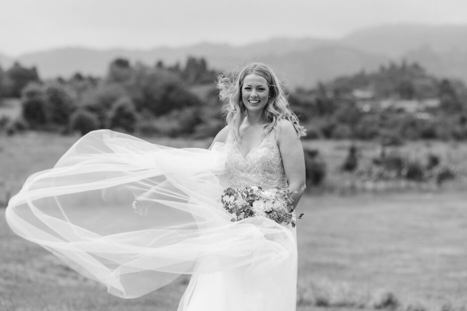 Black and White photo of bride holding back her veil in the wind at Longfords estate