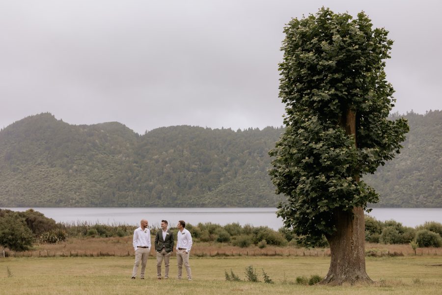 Groomsmen with country colours at Lake Okareka standing under tree in the field.