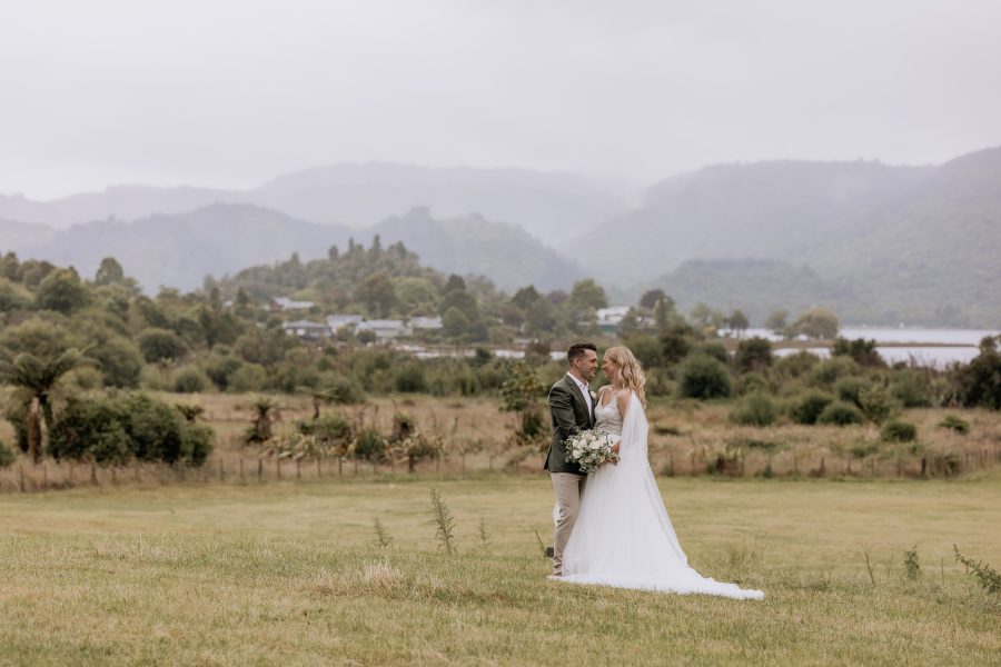 Wedding photo with Lake Okareka in distance with New Zealand lake and mountains in distance