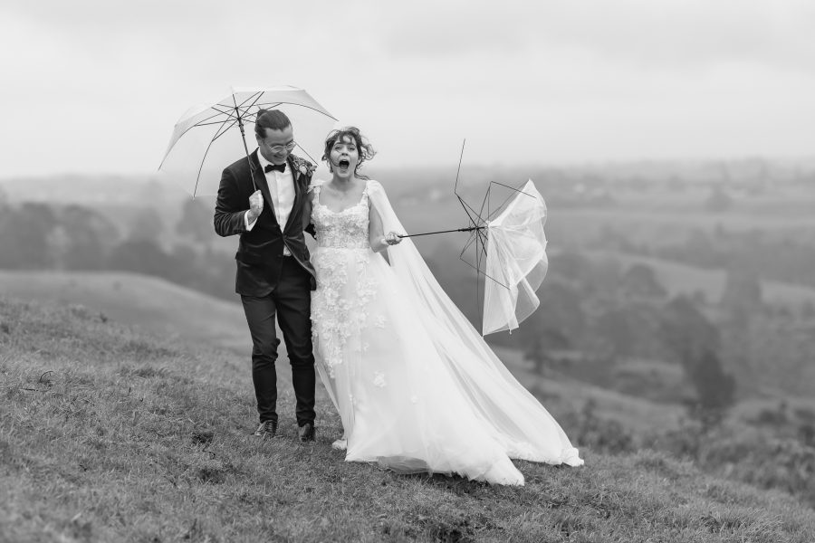 Wedding photo taken with umbrellas breaking at Eagle Ridge Tauranga Hills