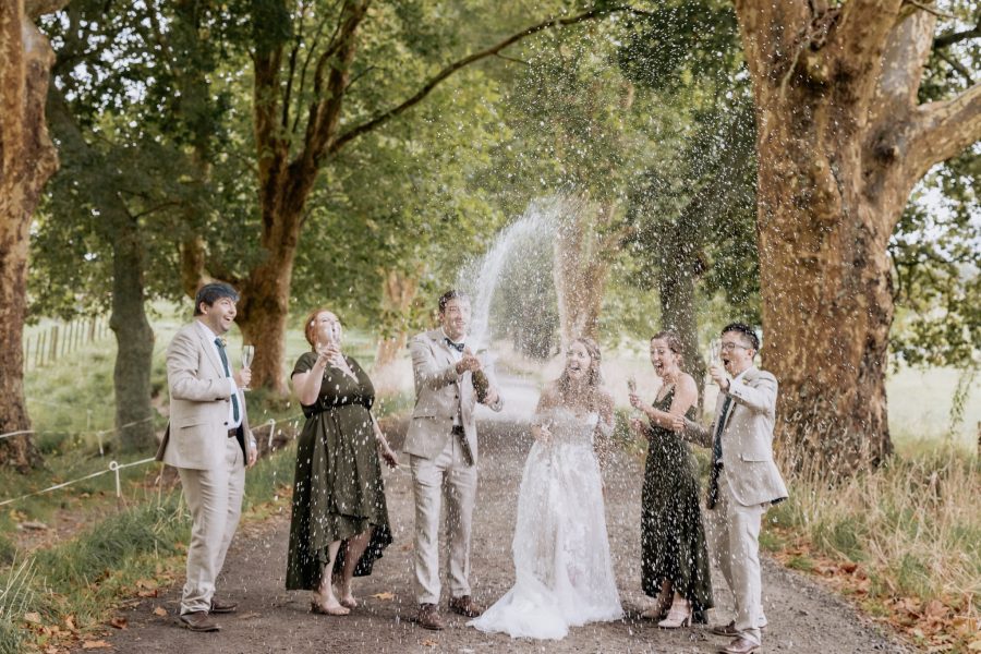 Champagne spray with party in olive green bridesmaids dresses