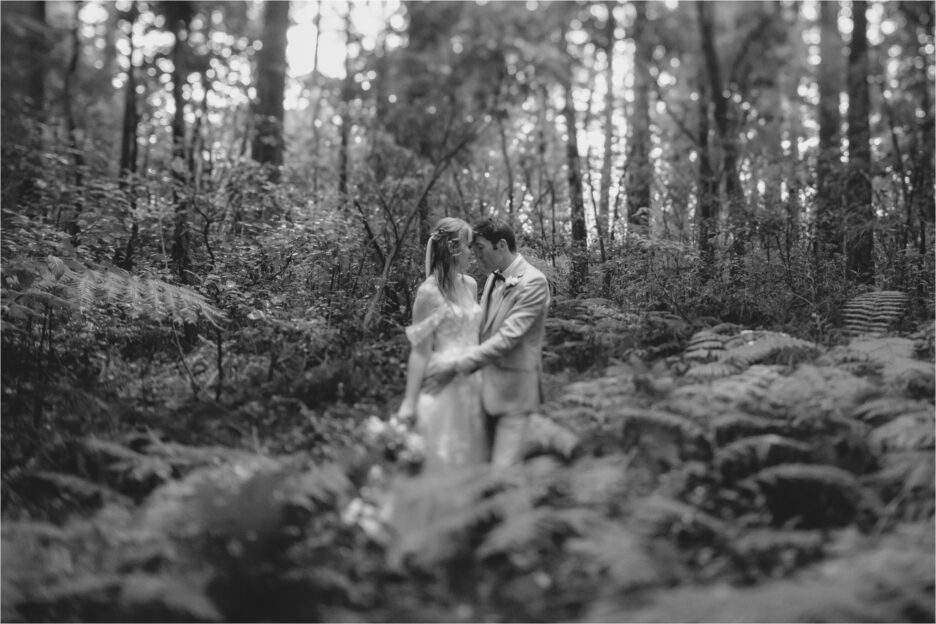 Bride and groom cuddling in the NZ bush during their photography