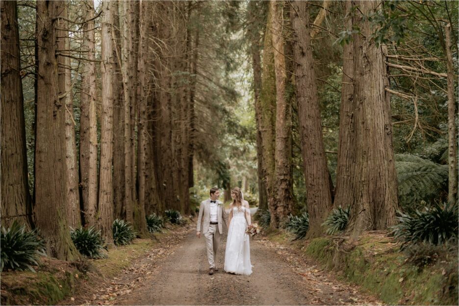 Bride and groom walking in the red wood trees at Longfords Estate