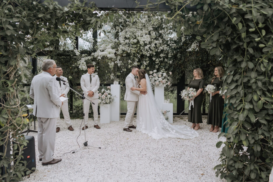 first kiss at end of ceremony inside glass house