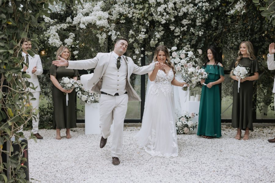 Happy groom dances down the aisle at black walnut wedding venue