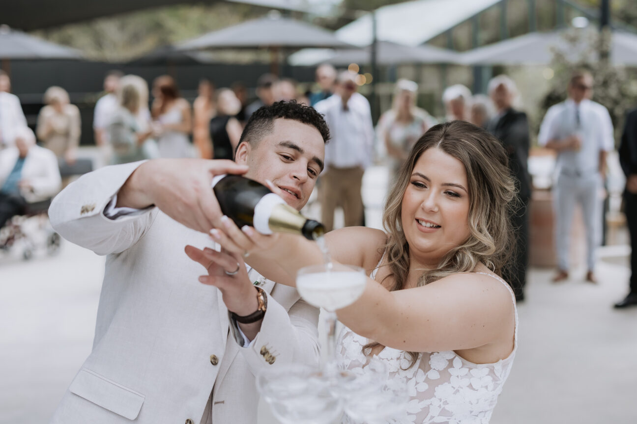 bride and groom filling champagne tower