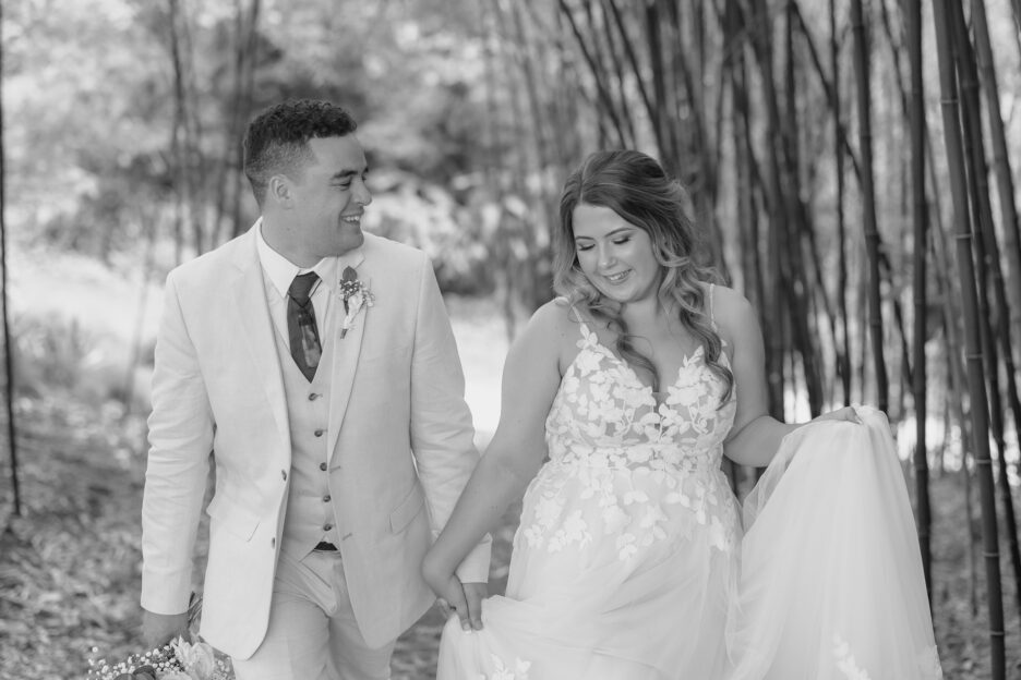 black and white photo of wedding couple walking at black walnut in bamboo trees