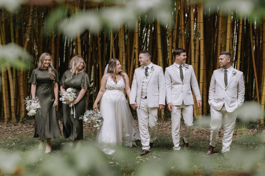wedding party walking in front of the bamboo trees in olive green black walnut venue