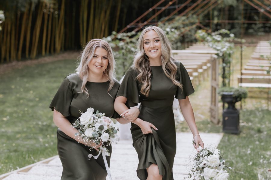 Happy Olive green bridesmaid walking together in front of tree church