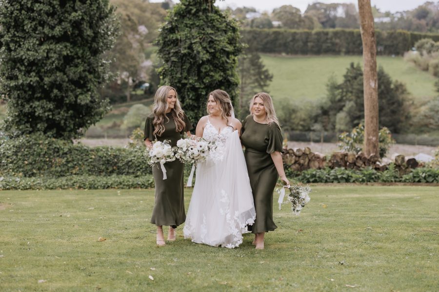bride walking with her bridesmaids in olive green at black walnut in tauranga