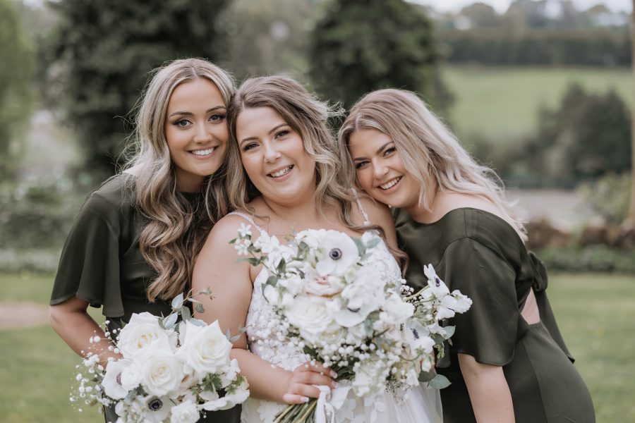 happy bride with her bridesmaids in olive green black walnut