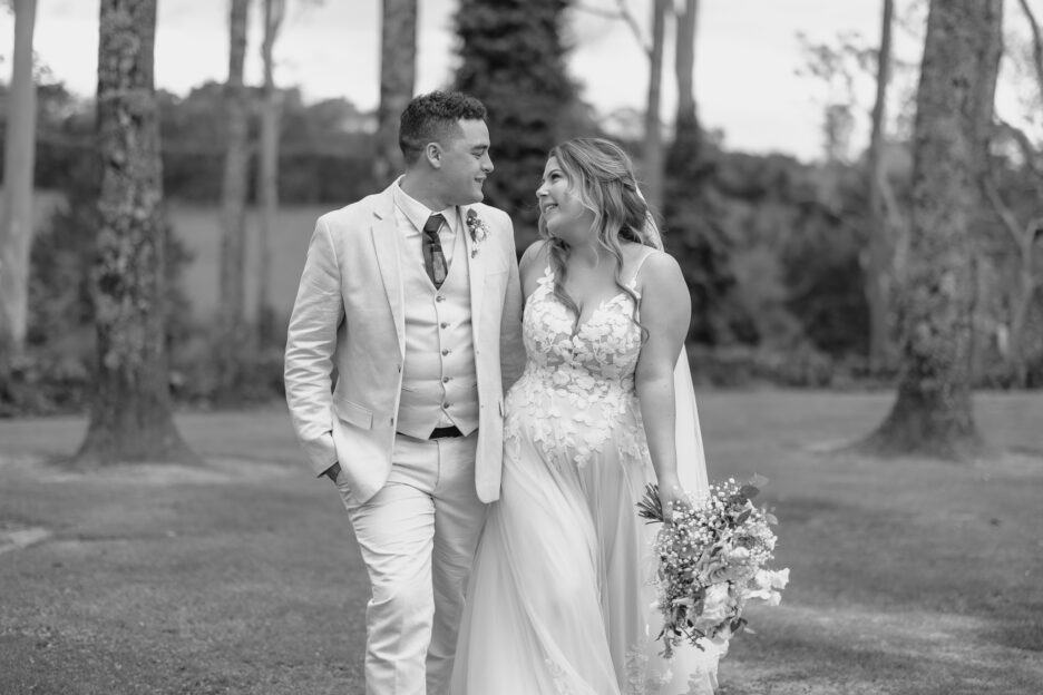 happy couple looking at each other walking in at black walnut taurana wedding venue