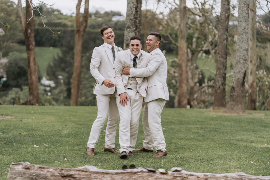 groomsmen and groom laughing at black walnut venue