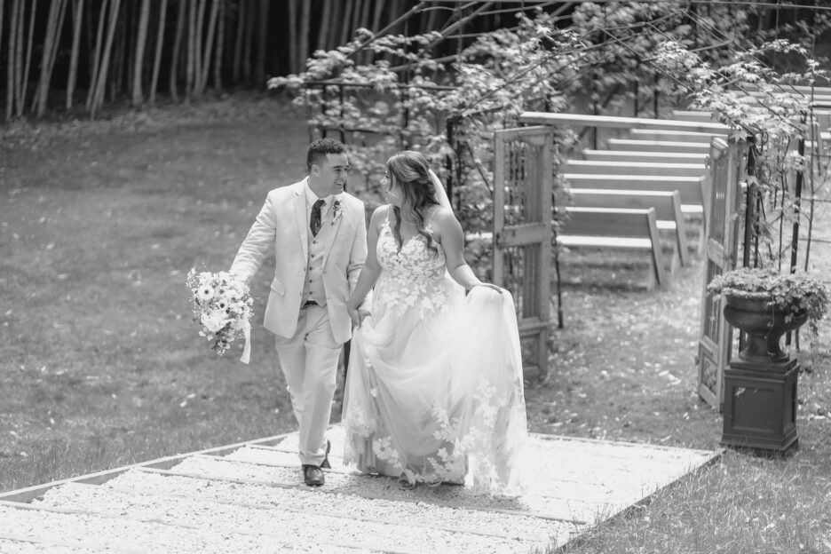 happy couple walking away on steps by tree church at Black walnut wedding venue in Tauranga