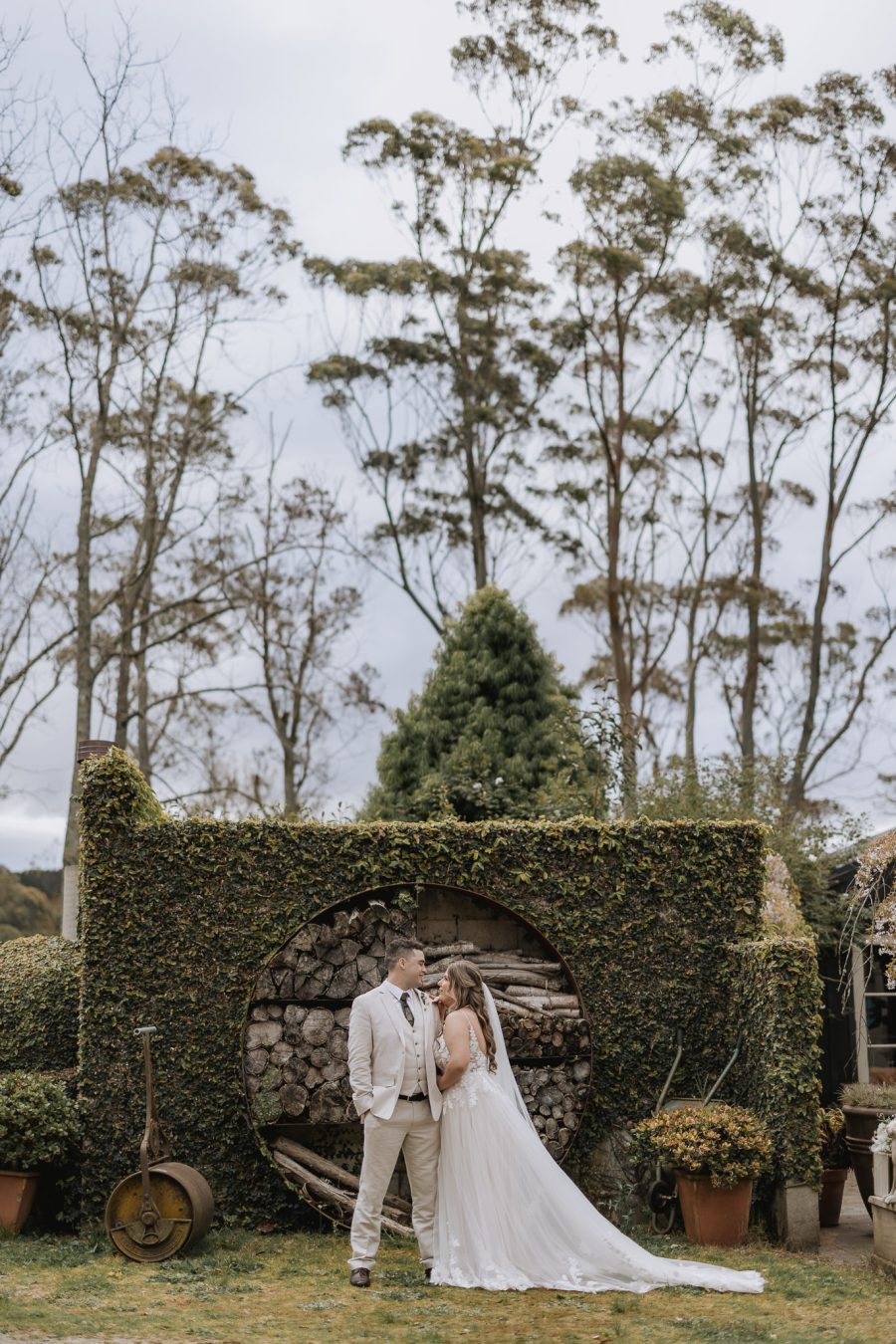 bride and groom in front of firewood