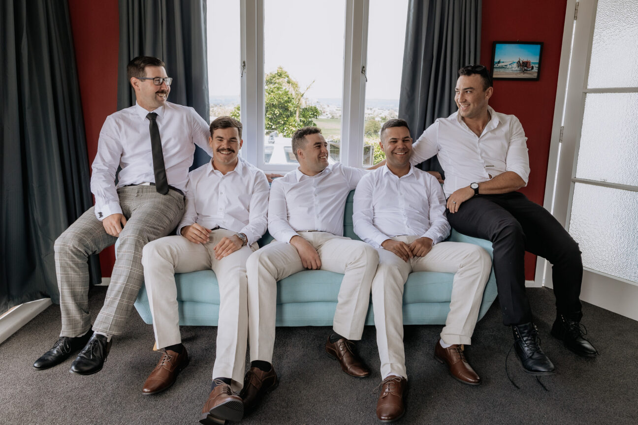 groom with groomsmen before wedding sitting on couch