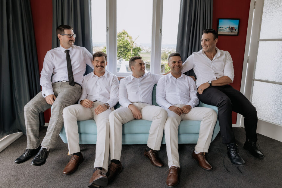 groom with groomsmen before wedding sitting on couch