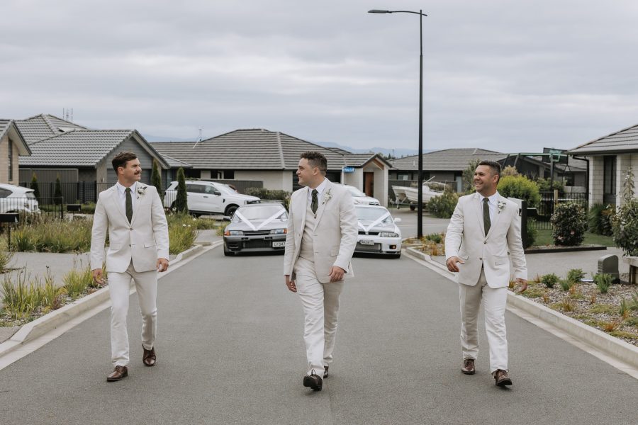 groomsmen walking in front of wedding cars in tauranga