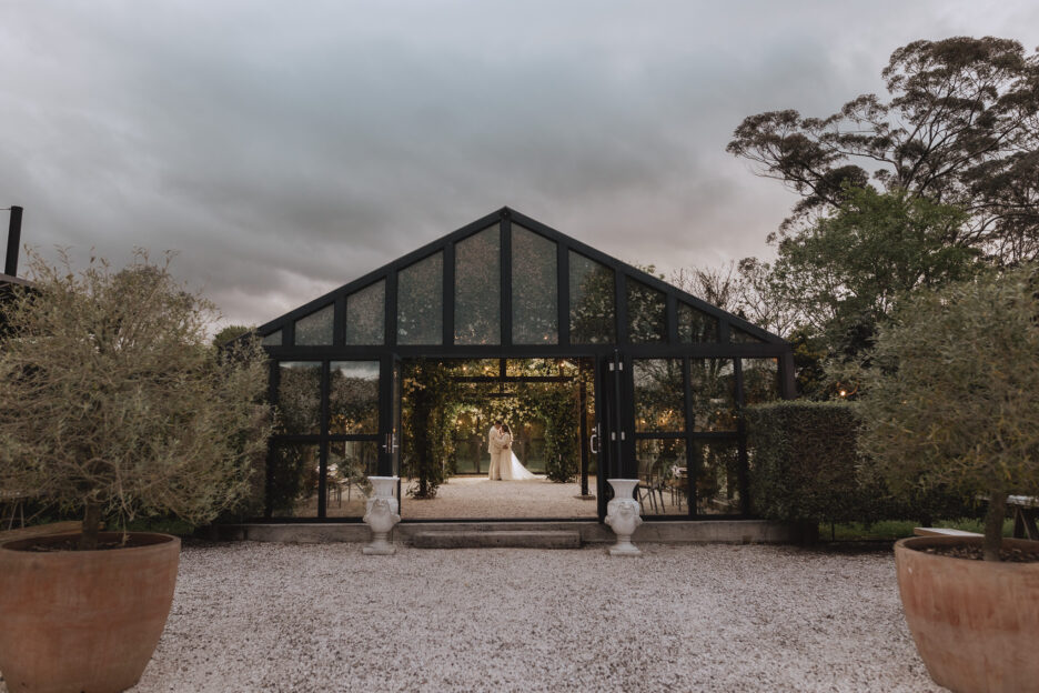 bride and groom at sunset in glass house at Black Walnut wedding venue