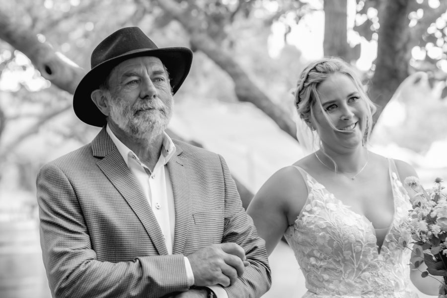 Happy bride and proud father of the bride walking down aisle at Te Tumu estate