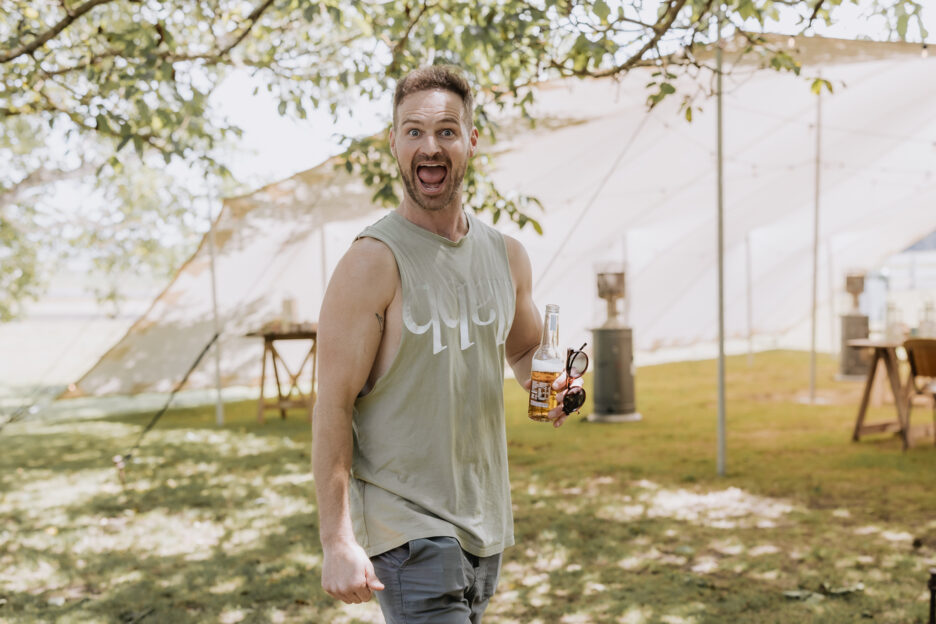 Groom walks past holding beer can before wedding