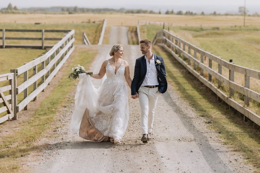 bride and groom walking down lane Te Tumu Estate