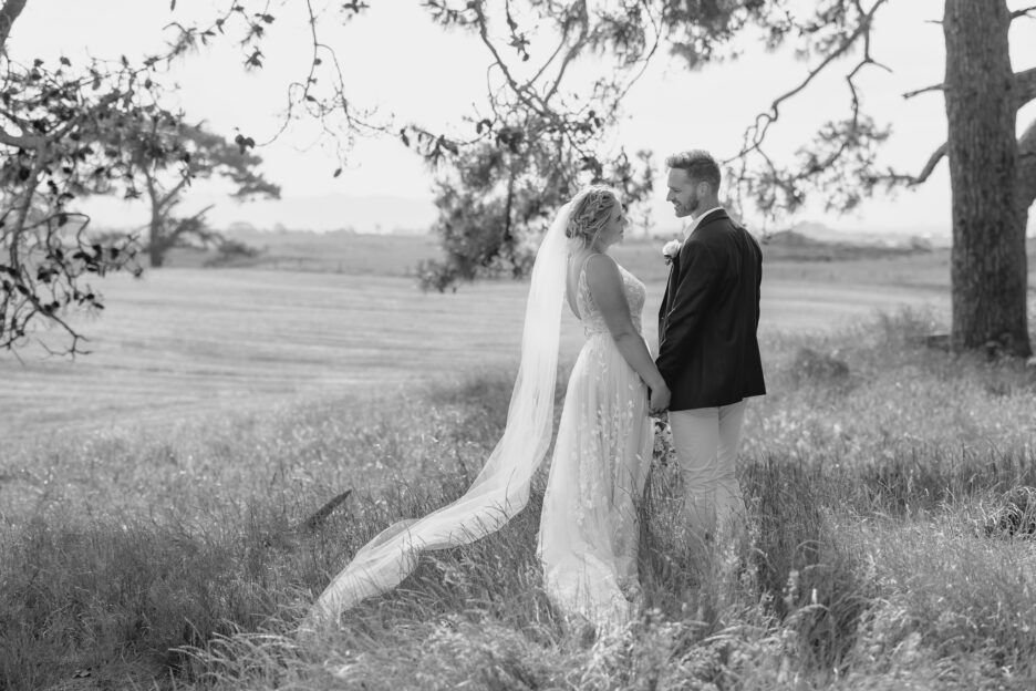 bride looking at groom under tree Te Tumu estate