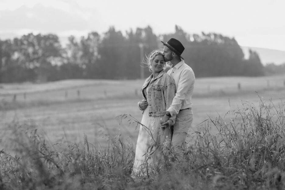 Wedding photo of groom kissing bride in country side Te Tumu Estate papamoa