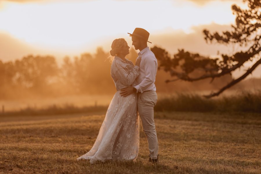 dusty road at golden hour with bride and groom Te Tumu Estate