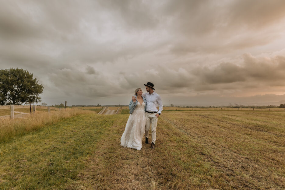 Cloudy skies te tumu estate groom and bride walking