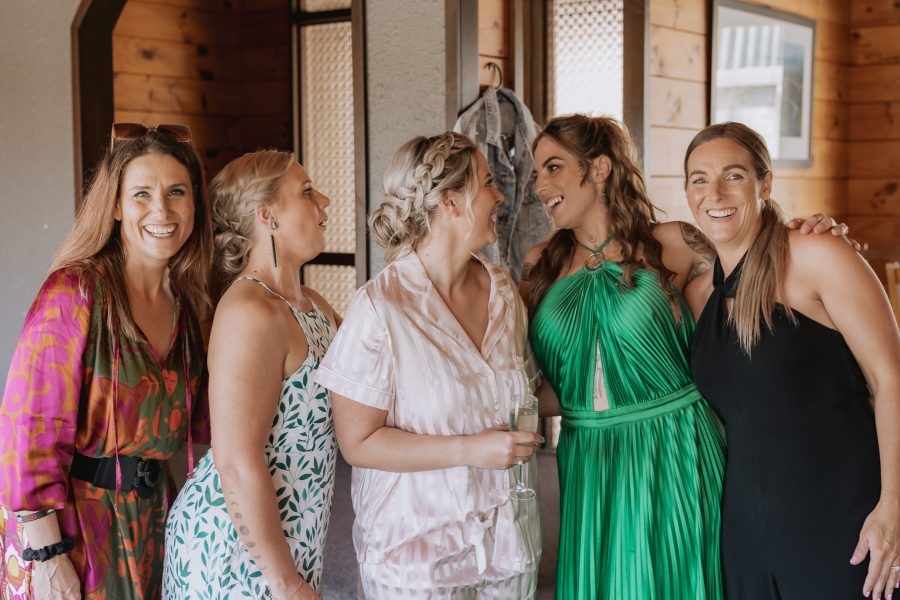 Bride with girlfriends before ceremony laughing