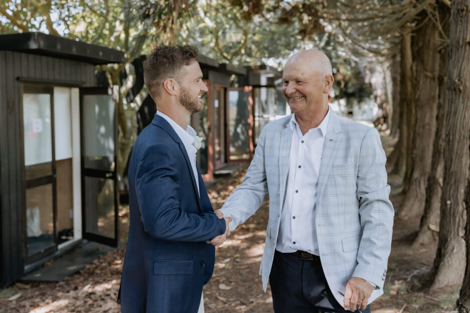 Groom greets father shaking hands