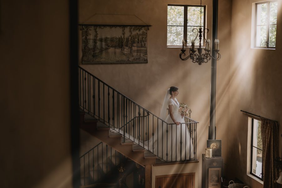Bride on stair case Villa vie with sun rays