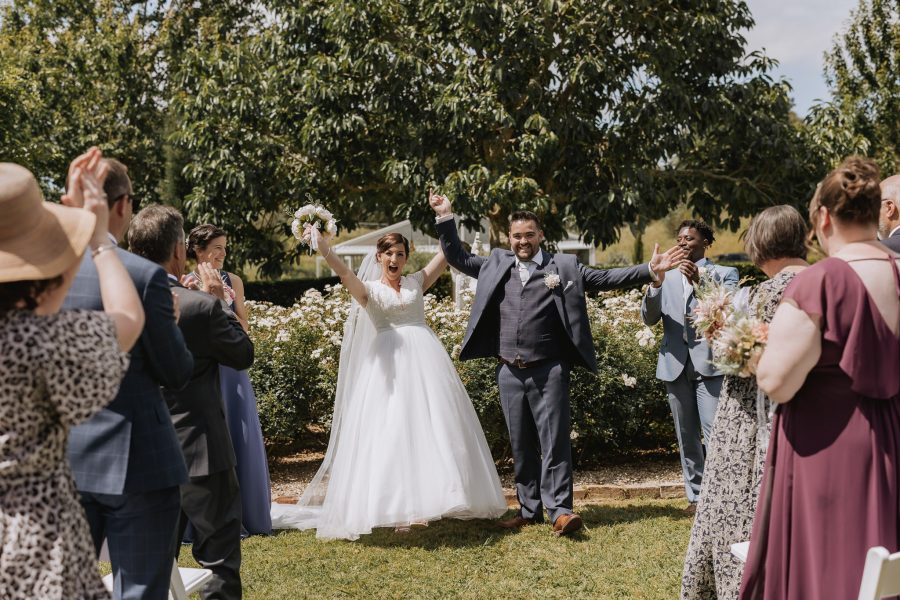 Bride and groom celebrate arms up