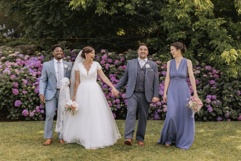 Wedding party walking in front of hydrangeas