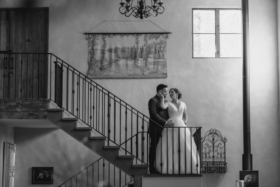 Bride cuddles groom Villa Vie staircase