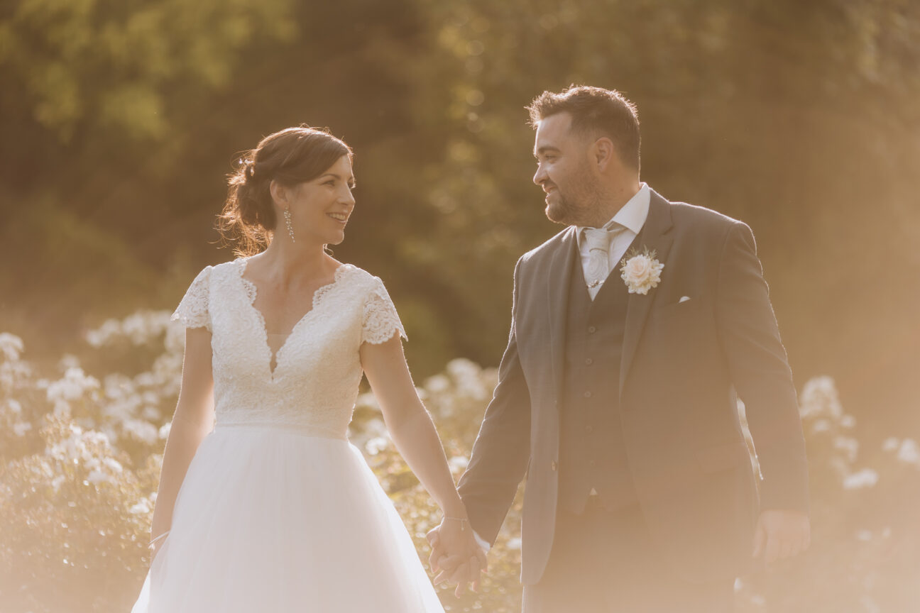 Bride and groom walking in sunlight Villa Vie golden hour