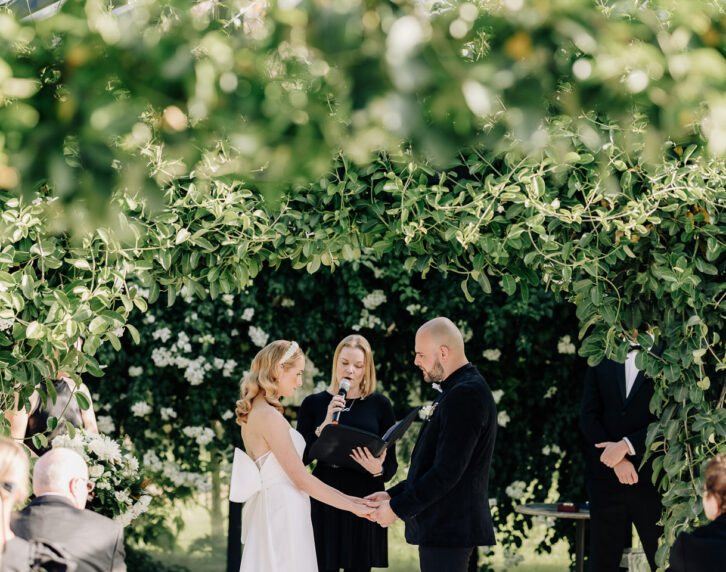 bride and groom in glass house getting married at Black walnut glass house surrounded by greenery