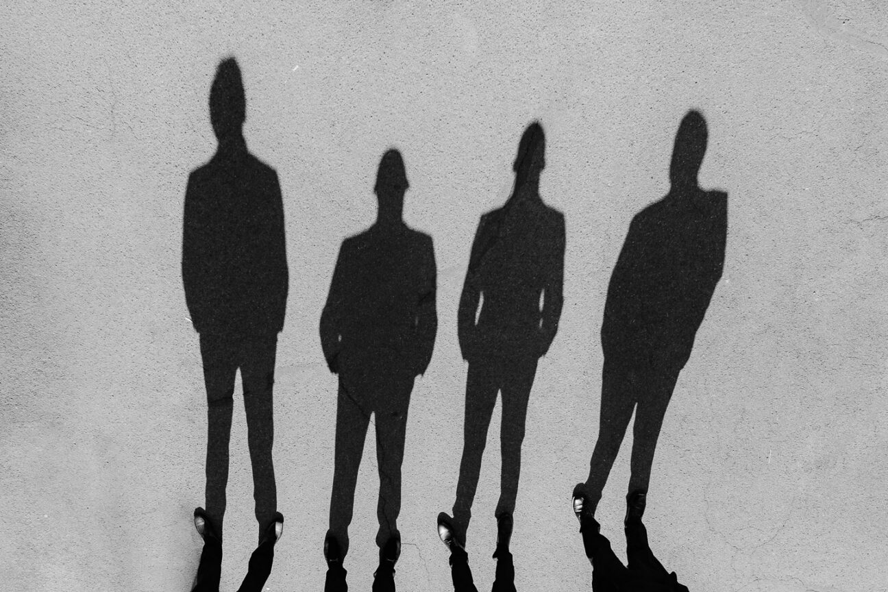 Shadows of four groomsmen in the concrete