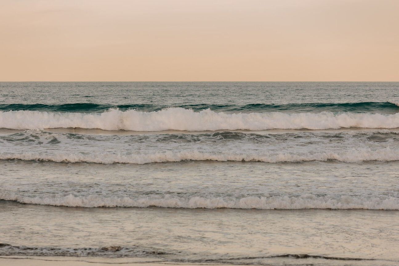 Sunset behind waves waihi beach