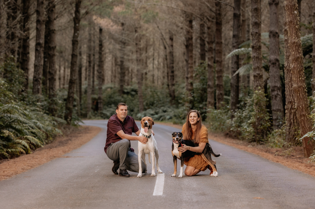 Couple in forest with their two dogs for what to wear for photo shoot article