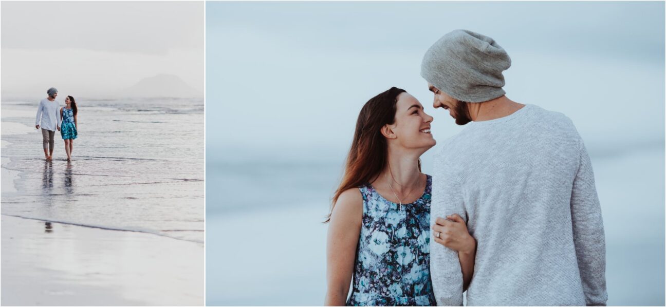 Engaged couple wearing blue and grey walk beach cloudy day