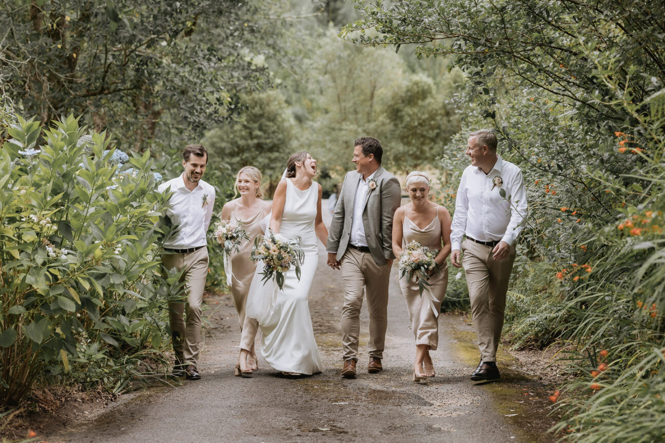 laughing wedding party walking up driveway at old forest school