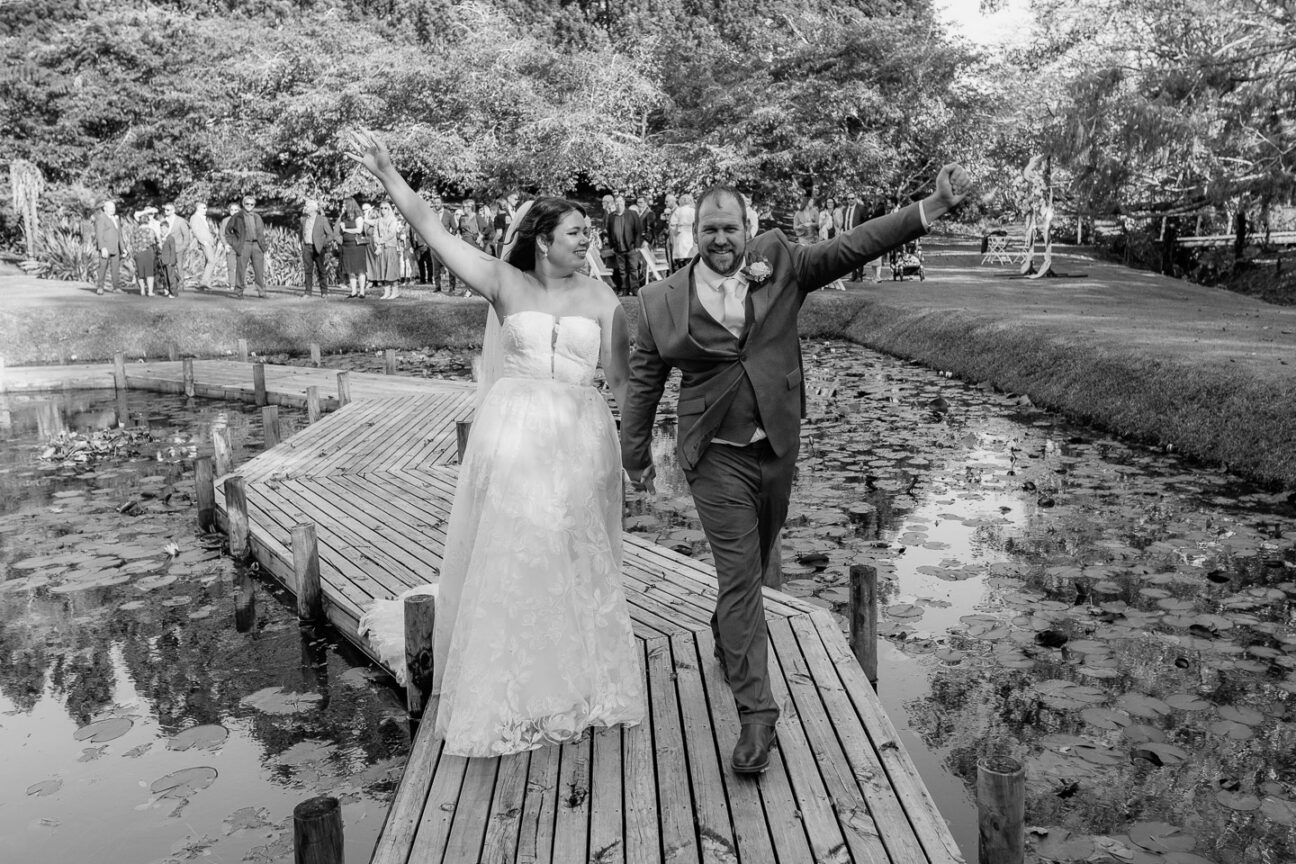 bride and groom throw hands up happy they are just married