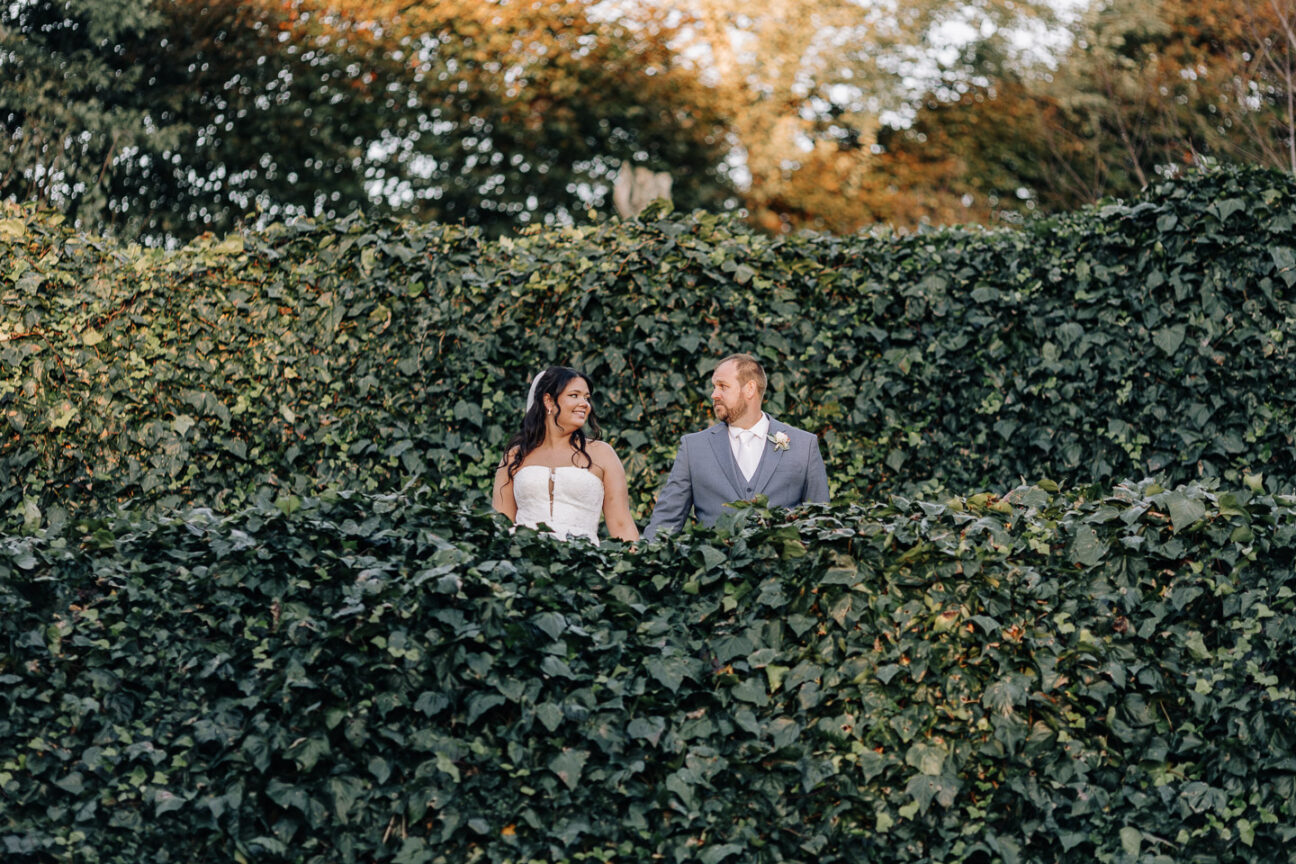 Bride and Groom standing green ivy wall waterlily gardens