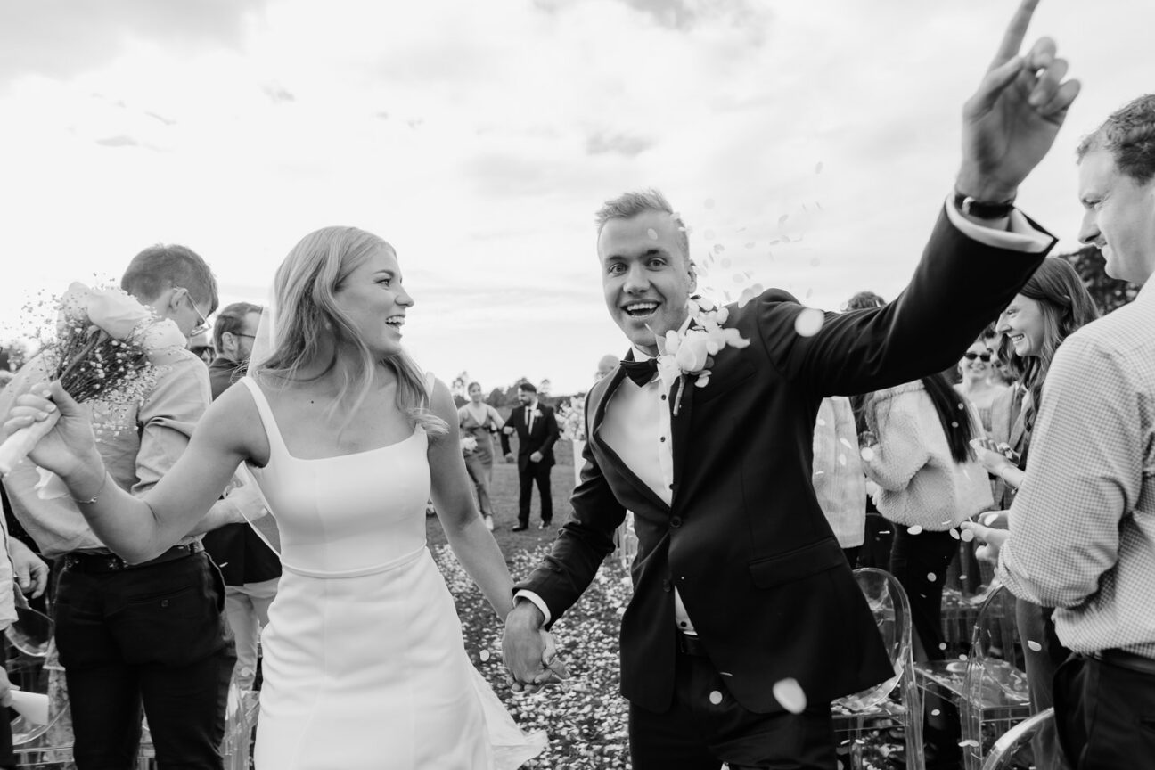 groom celebrating walking down aisle