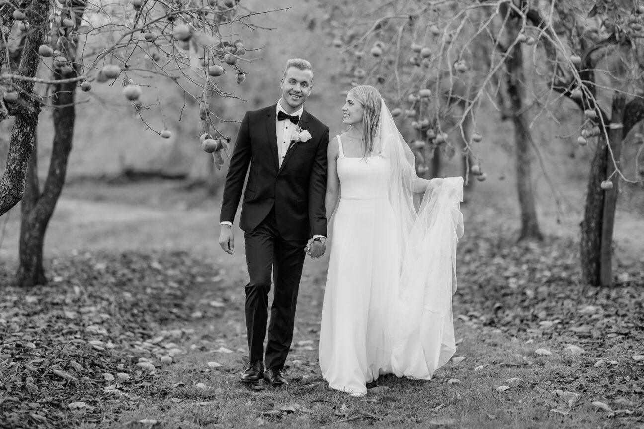 wedding couple walking in orchard
