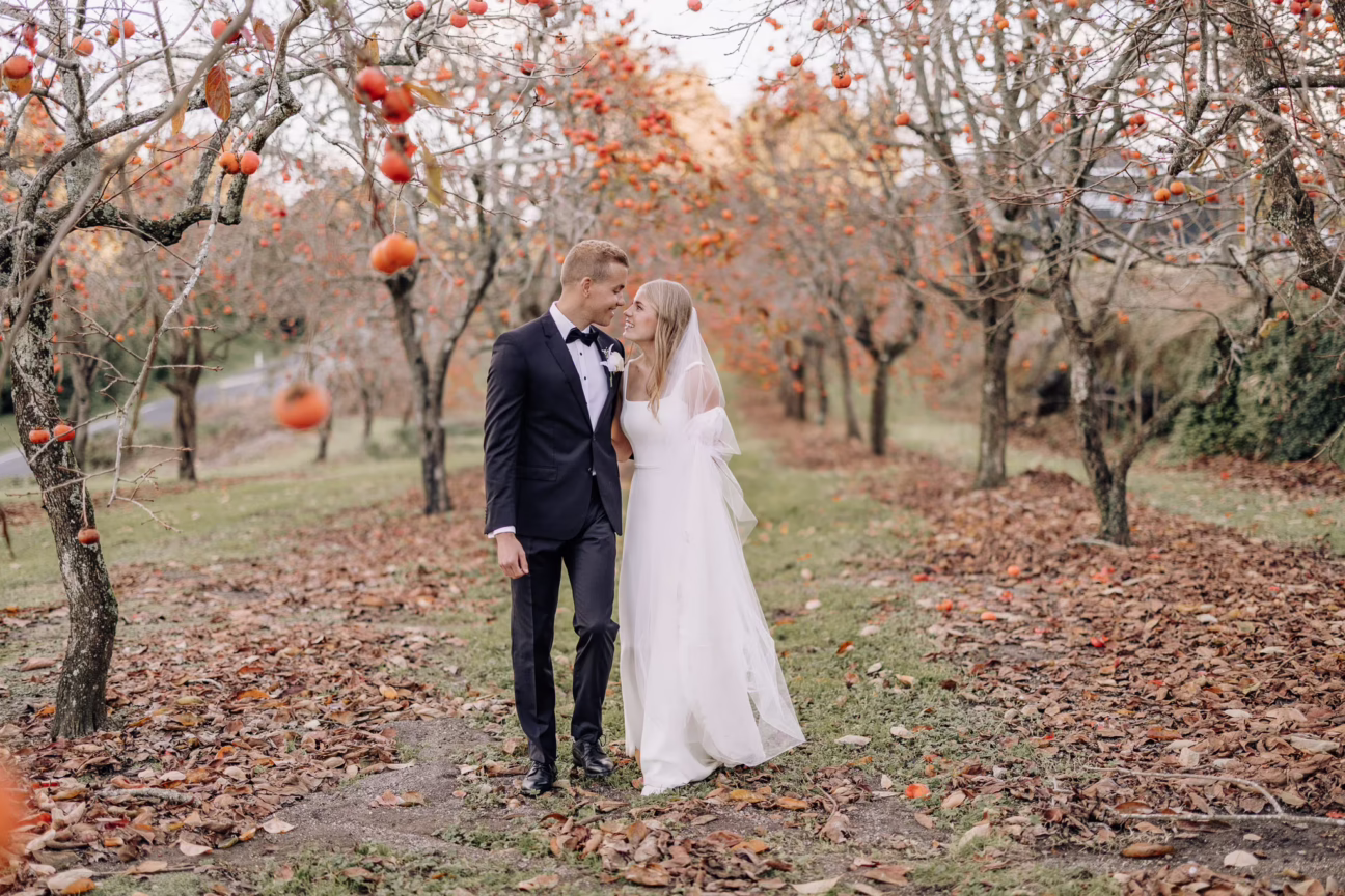 wedding couple walking in persimmon's Amberlee gardens Te Puke