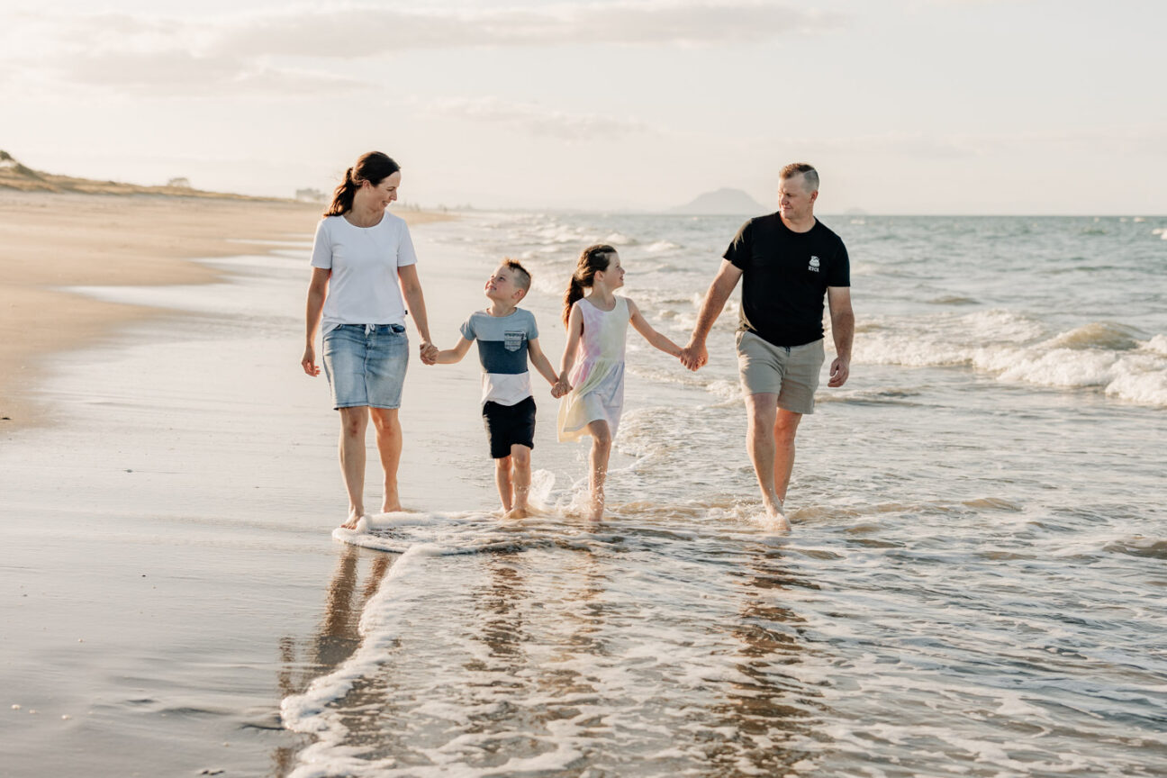 family walking in water papamoa beach photos