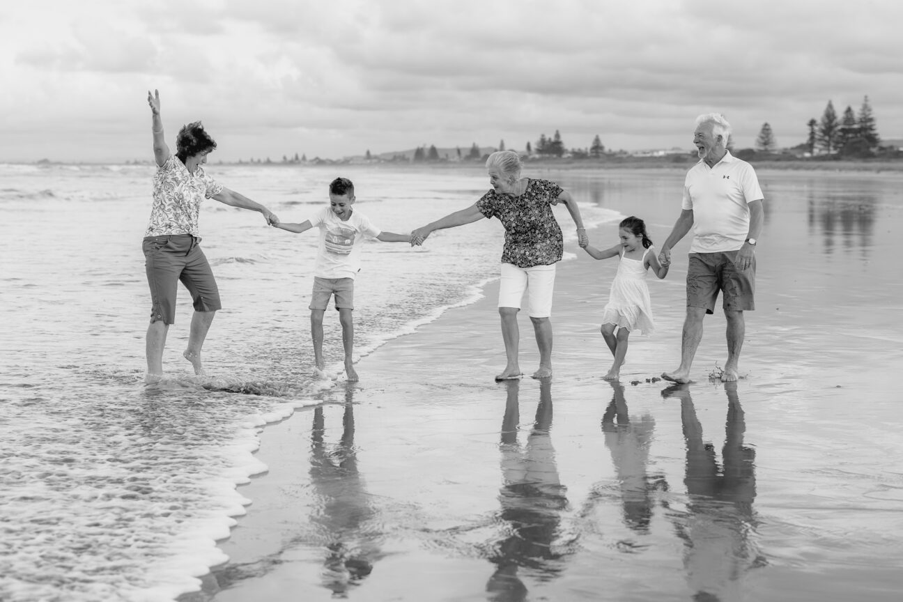 family photo fun with grandparents and grandchildren playing on beach